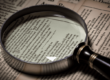 Regulatory Intelligence symbolisiert durch eine Lupe vor Gesetzestexten