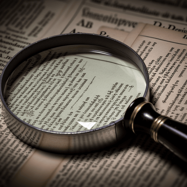 Regulatory Intelligence symbolisiert durch eine Lupe vor Gesetzestexten