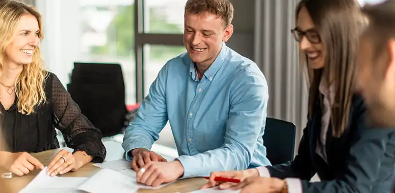Fröhliche Menschen im Büro analysieren Dokumente