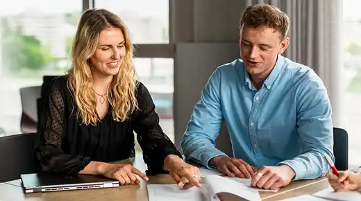 Mann und Frau schauen sich im Büro Dokumente an