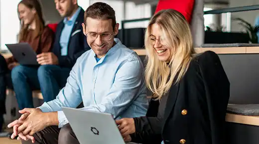 Mann und Frau im Büro schauen sich etwas am Laptop an