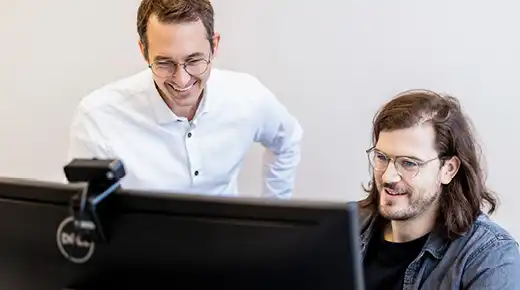 Zwei Kollegen schauen sich etwas am Computer an