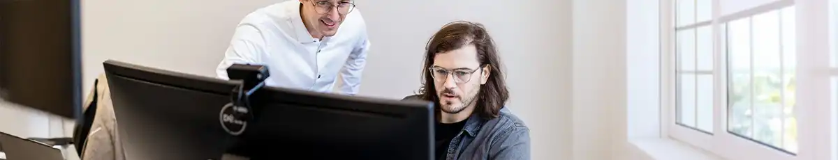 Man helps another man work on the computer