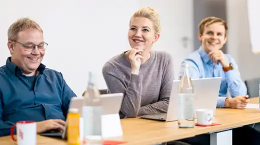 Three People in an Office Listening to a Presentation