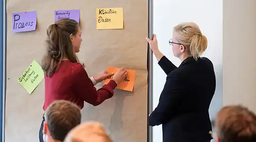 Zwei Expertinnen beschriften Klebezettel