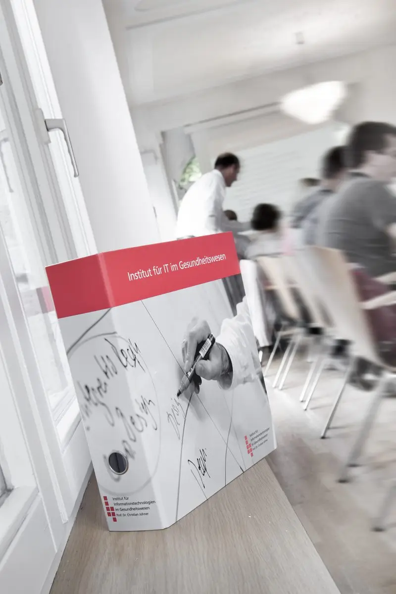 Räume des Johner Instituts mit Roll-up und arbeitenden Mitarbeitenden.
