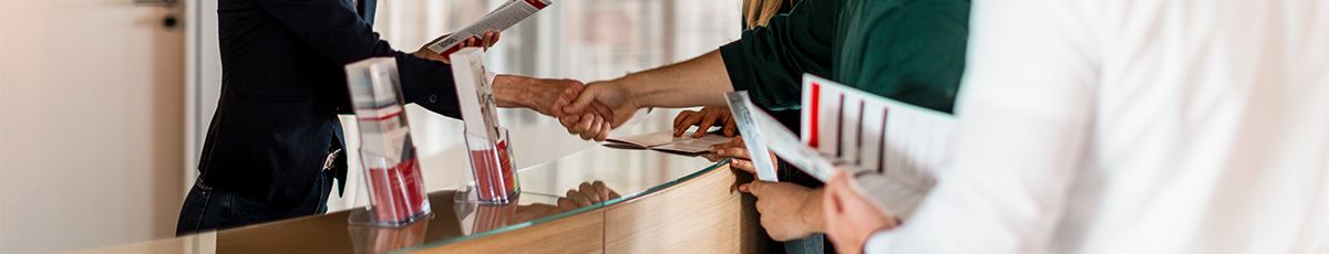 Handschlag und Flyer-Präsentation am Empfang