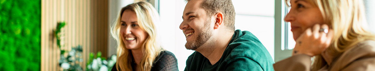 Glückliche Mitarbeitende sitzen im Büro
