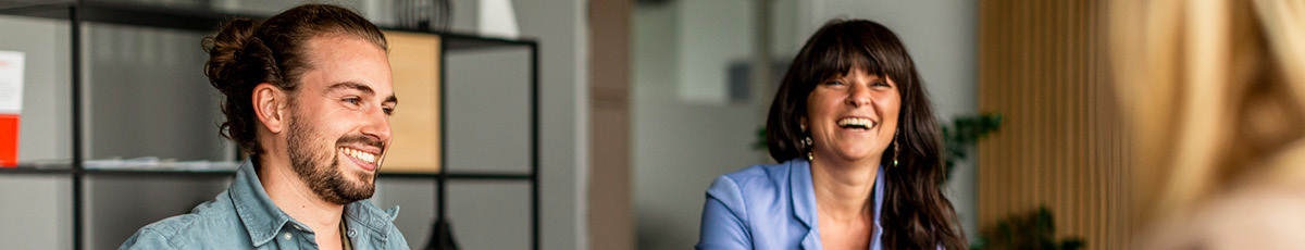 Lachende Mitarbeitende im Büro