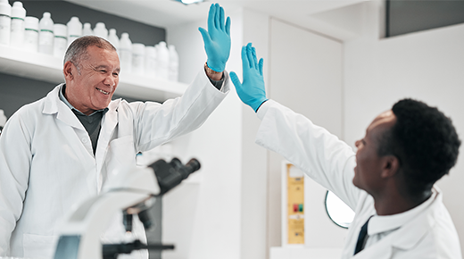 Zwei Kollegen im Labor geben sich ein High-Five