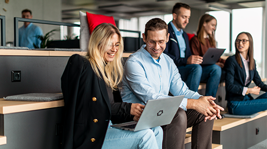 Menschen im Büro schauen sich etwas am Laptop an