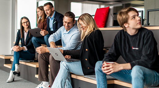 Kollegen im Büro sitzen zusammen an Laptops