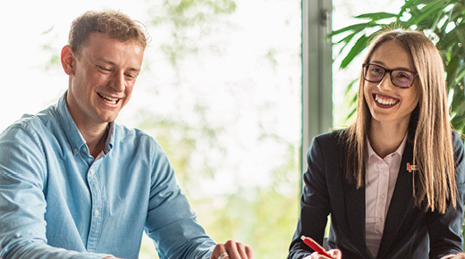 Frau und Mann im Büro lächeln