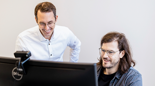 Zwei Kollegen schauen sich etwas am Computer an