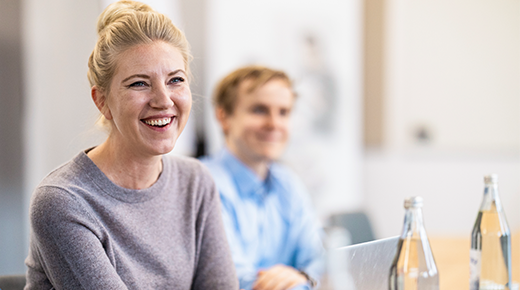 Lachende Frau und Mann im Büro
